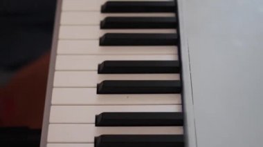 Genç kadın elini bileziğinde ile elektronik synthesizer üzerinde çalış ve anahtarları onun parmaklarıyla dokunur.