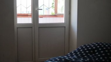 Kot pantolon ve T-shirt genç yalınayak kadın kapı ve adımları da balkona açılır.