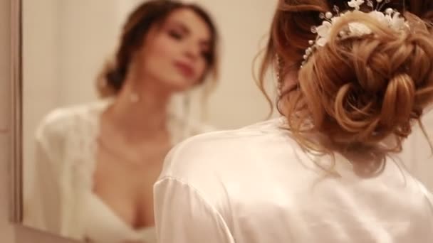 快乐的新娘在白色胸罩和 Peignoir 敬佩她的反射在镜子在她的婚礼天 — 图库视频影像