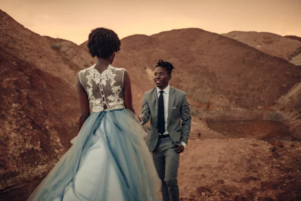 Siyah mutlu yeni evliler yürüyüş Kanyon günbatımı güzel manzaraya karşı.