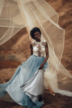 Güzel manzara arka plan üzerinde siyah gülümseyen gelin uzun gelinlik ve gelin peçe standları.