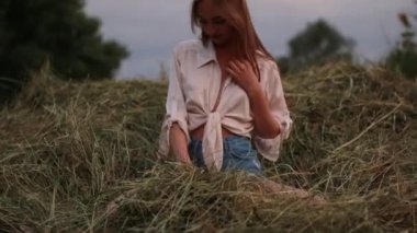 Genç kadın bir haystack eğlenir ve atar ile saman demet.