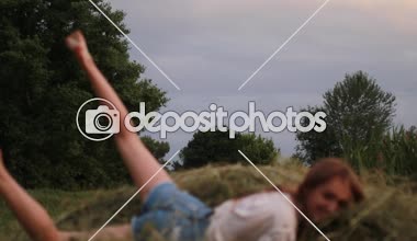 Genç kadın çayır, haystack için atlar arasında çalışır ve o eğlenceli ve rahatla.