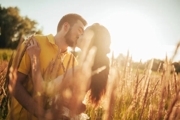 Fiatal Szerelmes Pár Megcsókolja Hugs Réten Háttérben Tüskék Háttérvilágítással — Stock Fotó