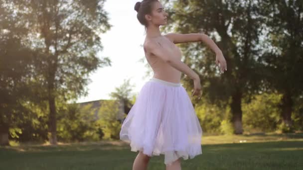 Ballerina Witte Transparante Jurk Dansen Achtergrond Van Gazon Bomen Achtergrondverlichting — Stockvideo