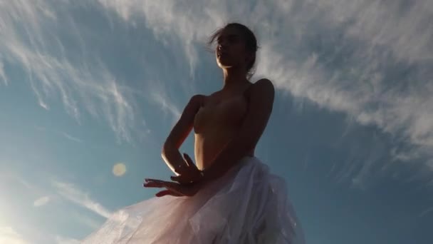 白色透明连衣裙的芭蕾舞演员在日落的蓝天下跳舞 底部视图 — 图库视频影像