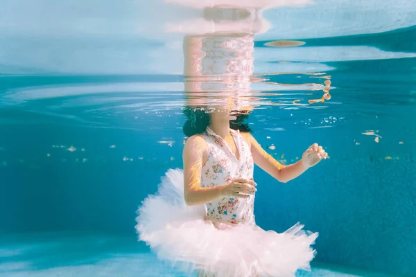 芭蕾舞演员正在水下跳舞 背景是气泡和漂浮的树叶 她在水中的倒影是可见的 — 图库照片