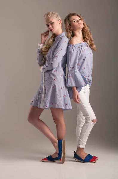 Дві Блондинки Блакитній Сукні Блузка Білими Джинсами Позують Студії Сірому — стокове фото