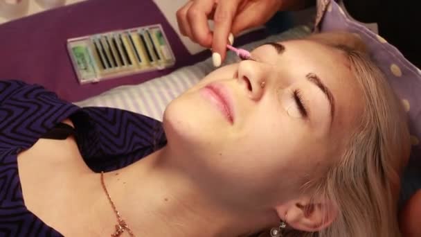 大师延长妇女的睫毛和梳子他们的画笔在美容院 — 图库视频影像