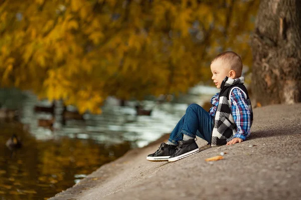 Een Jongetje Zit Een Rots Naast Het Meer Tijdens Een — Stockfoto