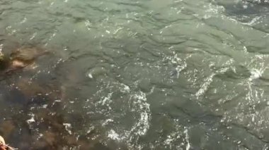 Büyük taş hızlı akan dağ nehir düşüyor ve ayrı havada uçan bir sürü sıçramalarına, kabarcıklar, dalgalar ve su üretir keser. Ağır çekim.
