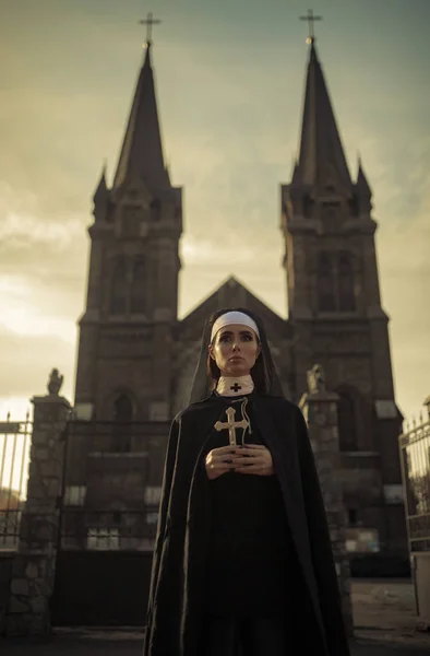 수녀와 배경에서 그녀의 십자가 — 스톡 사진