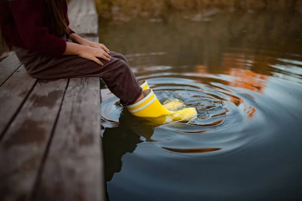 Kind Gele Rubberen Laarzen Zit Houten Brug Zet Haar Benen — Stockfoto