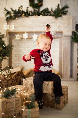 Çocuk oğlan çocuk oyuncak araba Noel ağacı ve festival çelenk arka plan üzerinde oturuyor. Siyah beyaz resim.