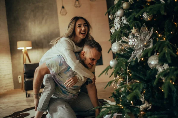 Jovem Casal Apaixonado Divertindo Rindo Alegremente Fundo Árvore Natal Lâmpada — Fotografia de Stock