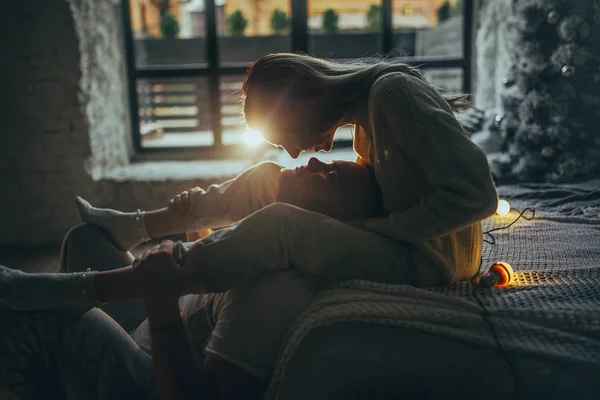 Młoda Para Miłości Przytulanie Całowanie Siedząc Łóżku Tle Choinki Świecące — Zdjęcie stockowe
