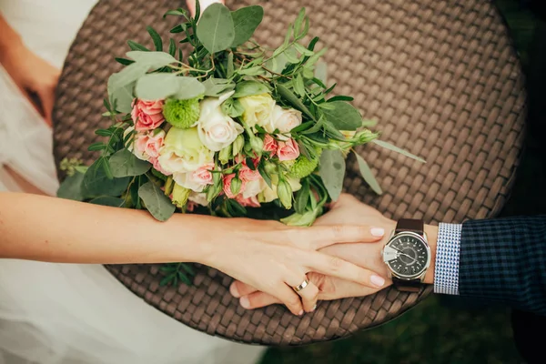 Menyasszony Vőlegény Ülni Asztalhoz Kéz Kézben Mellett Található Menyasszonyi Csokor — Stock Fotó