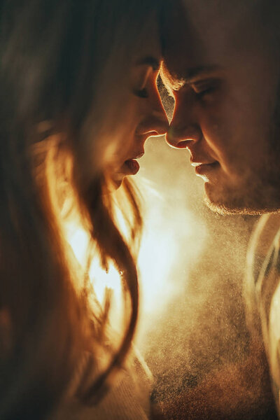 Портрет влюбленной молодой пары, стоящей лицом к лицу со светом лампы с подсветкой
.