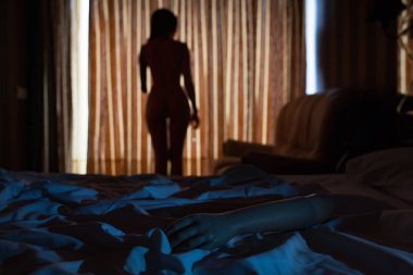 Protez kol arka plan olmadan bir kol pencerenin yanında genç bir seksi kadın yatakta yatıyor. Engelliler dolu dolu bir hayat kavramı.