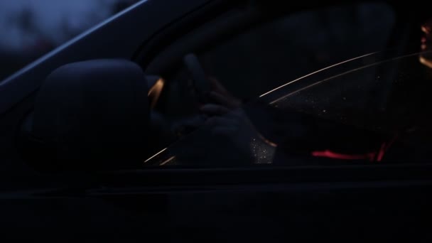 一个年轻的女人晚上坐在汽车的车轮旁 透过汽车的侧窗看 — 图库视频影像
