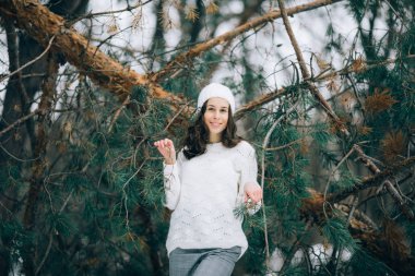 Genç kadın yanındaki çam ağacının gövde düşmüş kış ormanda yürüyüş sırasında duruyor.