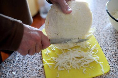 Erkek el Beyaz lahana Başkanı bıçağı masanın üzerinde bir kesme tahtası üzerinde doğrama. Portre.