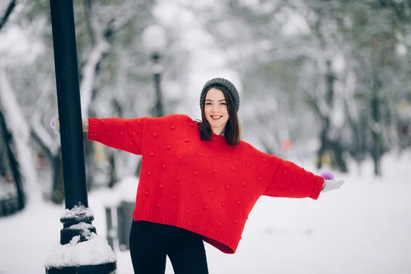 在冬天 穿红色毛衣的快乐女孩在雪街上玩得很开心 — 图库照片