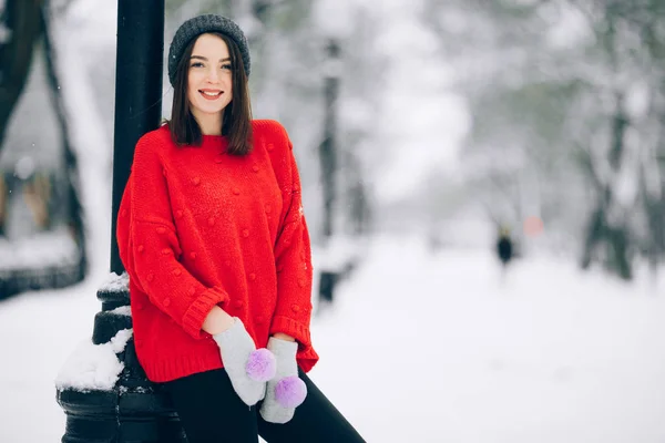 在雪街上散步时穿红色毛衣的漂亮女孩 — 图库照片
