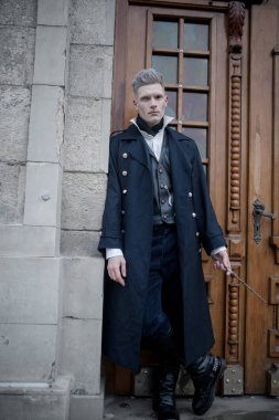 Kara büyücü görüntü genç adam elinde sihirli değnek ile caddenin yürür.