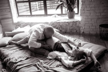 Genç adam bir yatakta w karşı bir karın hamile eşi öper