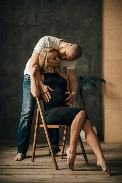 若い男が彼の妊娠中の妻をキスします。. — ストック写真