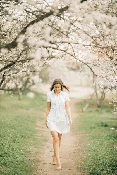 Genç bir kadın çiçek açan Bahçe arasında yürüyor..