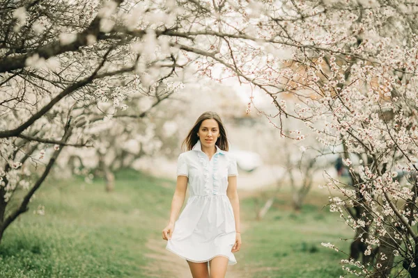 Una giovane donna cammina tra il giardino fiorito . — Foto Stock