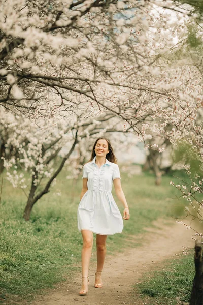 Молодая женщина гуляет среди цветущего сада . — стоковое фото