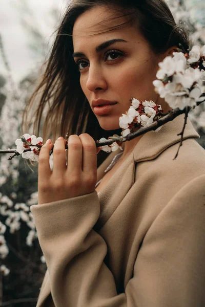 Портрет молодой женщины среди цветущих абрикосовых деревьев . — стоковое фото