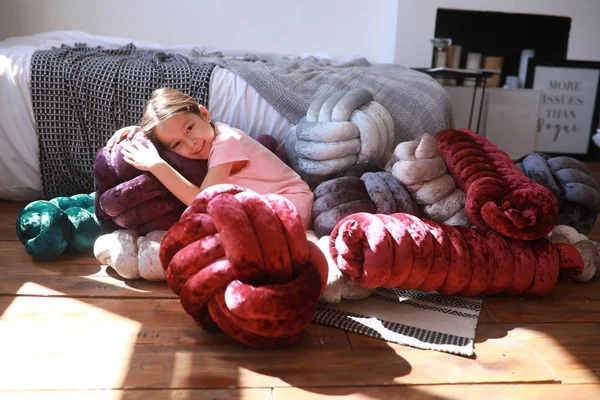 子供の女の子は珍しい多色の枕の中で床にリラックス — ストック写真