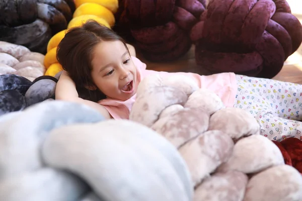 子供の女の子はパジャマの珍しい枕の中で床に遊びます. — ストック写真
