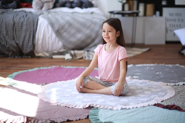 Niña hace ejercicios de yoga en la estera . — Foto de Stock