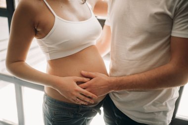 Bir adam hamile karısının karnına dokunur..