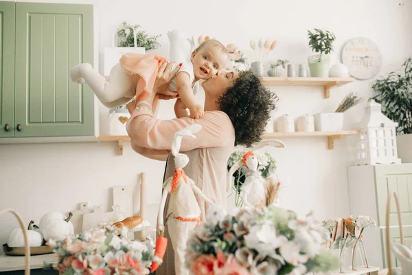 Lycklig mamma leker och kysser hennes barn i köket. — Stockfoto