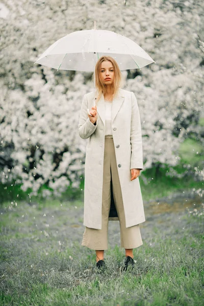 Une femme blonde se détend avec un parapluie dans ses mains parmi les spri — Photo