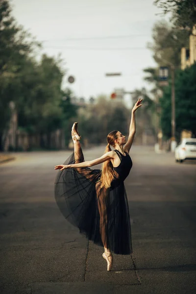 Ballerina standing in arabesque pose against the background of c