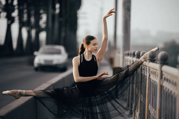 Ballerina sitzt in Bindfäden-Pose auf der Brücke gegen den Rücken — Stockfoto