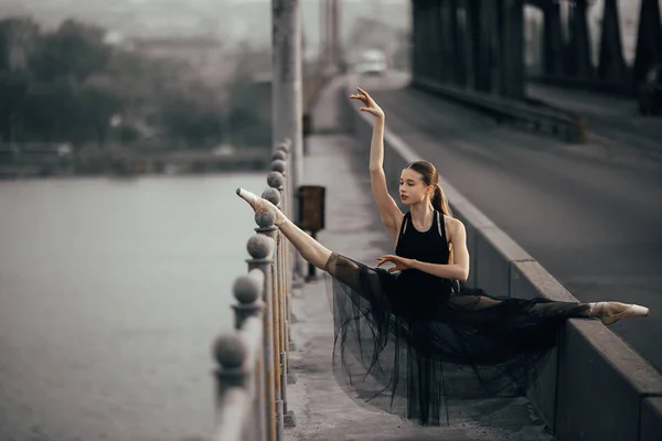 Ballerine assise en ficelle pose sur le pont à travers la rivière . — Photo