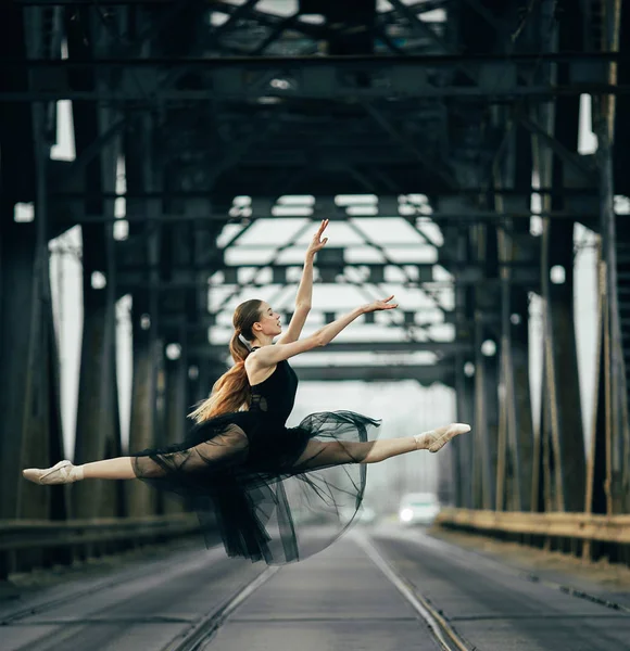 Ballerina jumping in twine pose on the road and rails. — Stock Photo, Image