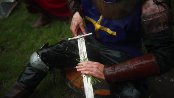 Young Man Sits Image Medieval Knight Armor Cleans His Sword — Stock Video