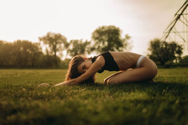 Žena dělá gymnastická cvičení vedle křídel zemědělského rozprašovače — Stock fotografie