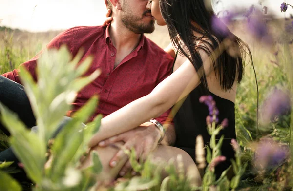 Um jovem casal está se beijando em um prado . — Fotografia de Stock