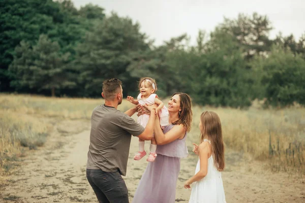 Família feliz com duas crianças se diverte e ri em uma caminhada . — Fotografia de Stock