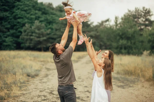 Família feliz se diverte em uma caminhada e vomita sua filha . — Fotografia de Stock